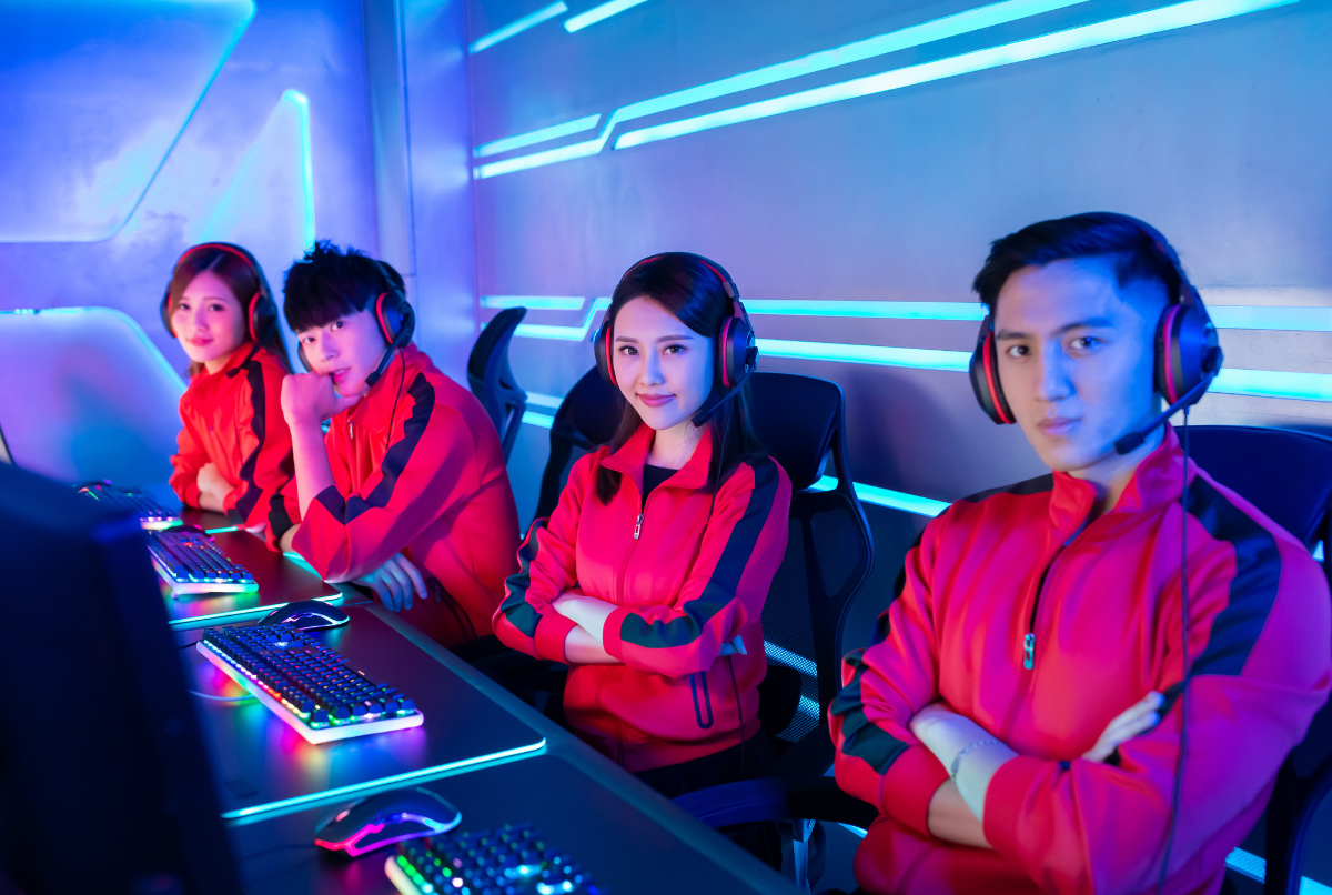 Pro player Indonesia dari tim esports ternama sedang berpose di panggung turnamen internasional dengan seragam merah khas tim.