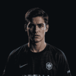 Tim Bren Esports bersiap di panggung turnamen, mengenakan jersey resmi dan menatap layar dengan fokus tinggi sebelum pertandingan dimulai.